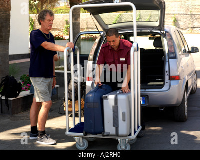 Palermo Sicily Italy Genoardo Park Hotel Bell Boy Putting Luggage into Car from Luggage Trolley Stock Photo