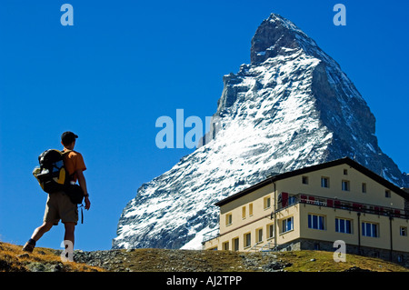 The Matterhorn (4477m). Hiker heading towards the Hornli Hut Refuge on a trail below the Matterhorn's peak, Zermatt, Valais Stock Photo