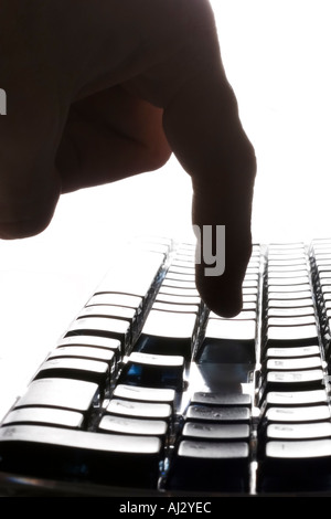 Finger pressing a key on a computer keyboard Stock Photo