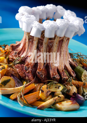 A crown roast lamb rack of ribs with roasted parsnips potatoes and carrots Stock Photo