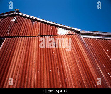 Rusty old shed set against a vivid blue sky. Stock Photo