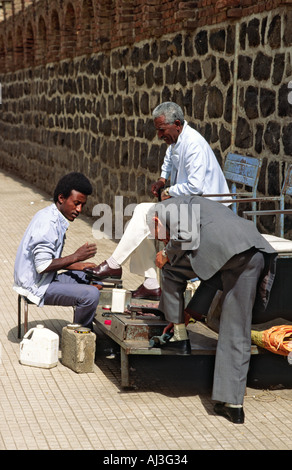 A shoe polisher doing good business on a street in Asmara. A love of good shoes is a legacy left by the country's Italian colonialists. Eritrea, Stock Photo