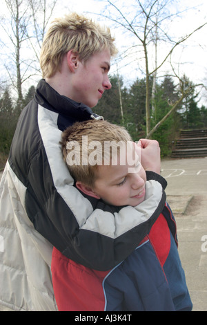 an older boy choking a younger one Stock Photo