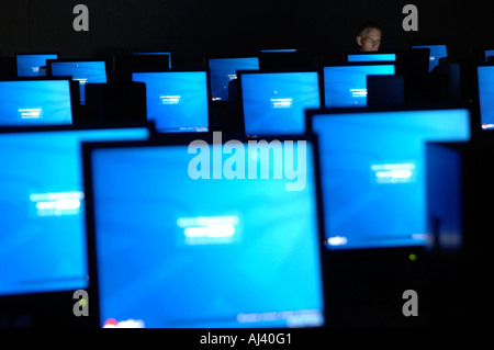 Computer terminals with man working late by himself Stock Photo