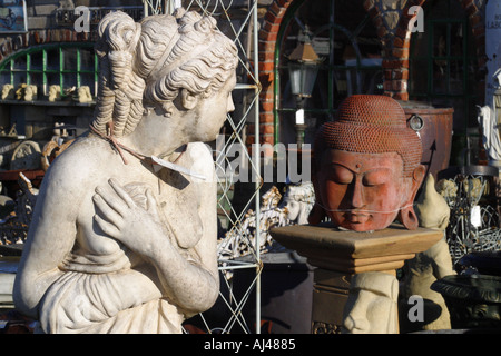 Salvage yard old statues female figure and buddha in an architectural reclamation yard Stock Photo