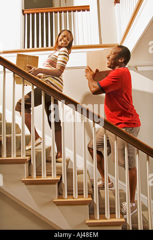 African couple carrying moving boxes Stock Photo