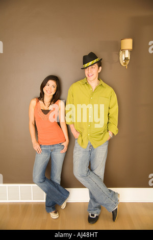 Young couple leaning on wall Stock Photo