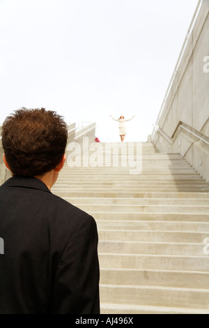 Businessman looking at businesswoman at top of steps