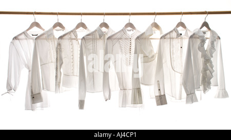 White ladies blouses hanging on a rail Stock Photo