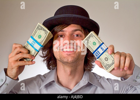 Young man in hat holding fistful of money Stock Photo