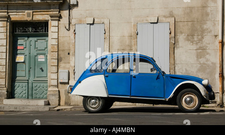 An old Citroen 2CV deux chevaux car parked infront of a traditional french building in Arles in Provence in France Stock Photo