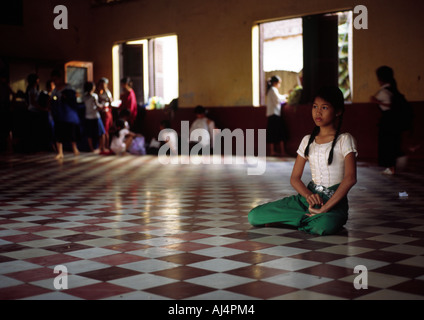 A young girl sits on the floor before a class in traditional dance at the Fine Arts School in Phnom Penh Cambodia Stock Photo