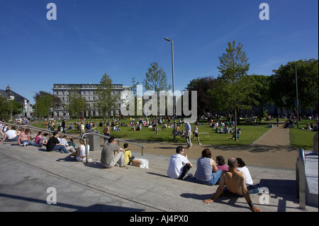 people sitting enjoying the sunshine john f kennedy memorial park eyre square Galway city county Galway Republic of Ireland Stock Photo