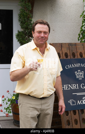 Claude Giraud, owner and winemaker, tasting a glass of his wine in the court yard in front of his house Champagne house Maison Giraud-Hemart, also called Champagne Henri Giraud, Ay, Vallée de la Marne, Champagne, Marne, Ardennes, France Stock Photo