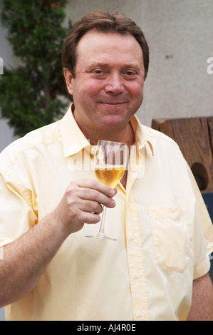 Claude Giraud, owner and winemaker, tasting a glass of his wine in the court yard in front of his house Champagne house Maison Giraud-Hemart, also called Champagne Henri Giraud, Ay, Vallée de la Marne, Champagne, Marne, Ardennes, France Stock Photo