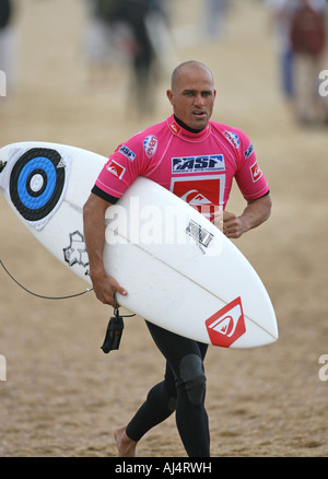 Pro Surfer Kelly Slater walking on the beach with his Surfboard under his arm Stock Photo