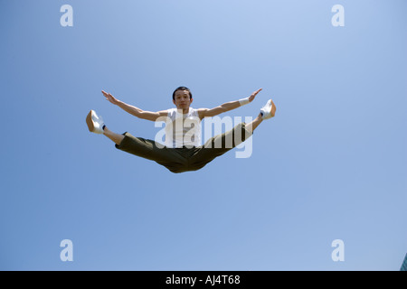 Young man jumping and doing splits in mid air Stock Photo