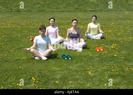Four young Woman sitting in lotus position Stock Photo