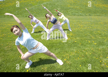 Four young Woman stretching in field Stock Photo