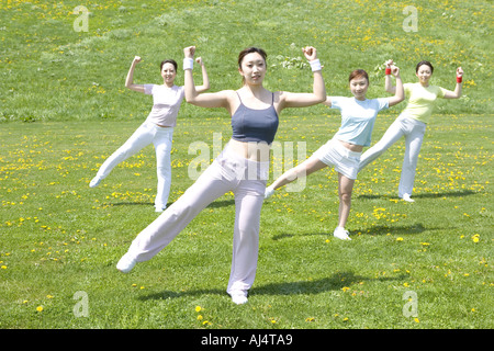 Four young Woman exercising in field Stock Photo
