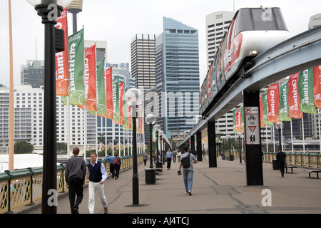 People walking over Pyrmont Bridge with Christmas decorations on a grey summer day in Sydney New South Wales NSW Australia Stock Photo