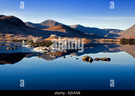 Lochan Na h Achlaise on a sunny winters morning Rannoch moor frozen Ice rocks Stock Photo