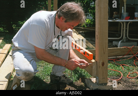 Man constructing deck Using socket wrench to drive screw Stock Photo