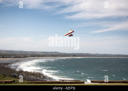 Tandem hang glider pilot flying hang gliding with passenger in sky from ridge by sea near Lennox Head in New South Wales NSW Stock Photo