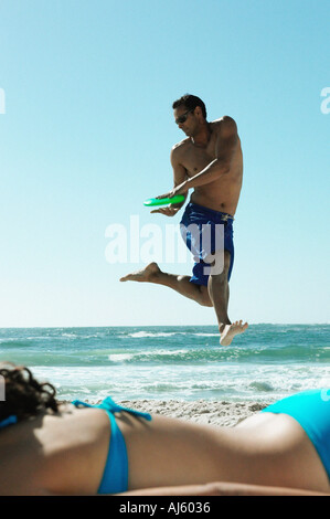 Man playing with frisbee on beach Stock Photo