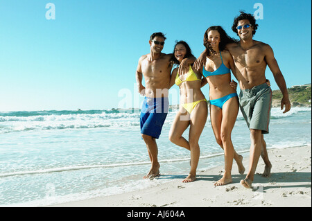 Young couples walking on beach Stock Photo