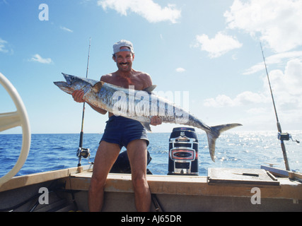 Fisherman holding large Spanish mackerel off Fraser Island in Australia Stock Photo