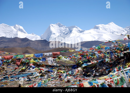 Prayer flags frame the vast Himalayan mountain range which is clearly seen from the top of the 5200m Shung La pass in Tibet Stock Photo