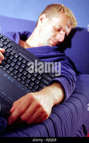 Mature man sleeping with a laptop in his hands. Stock Photo