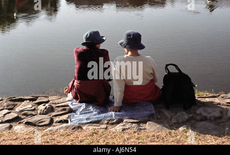 Two women on the banks of the Kamo River in Kyoto in late afternoon Stock Photo