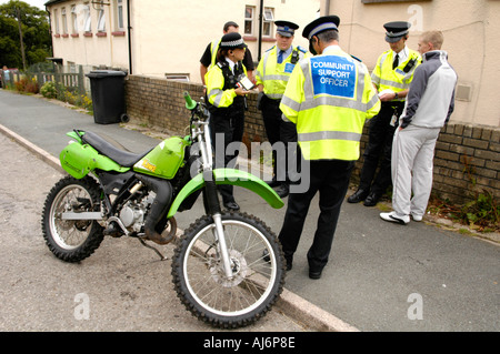 Police and Community Support Officers seize a scrambler motorbike being used illegally on the highway in UK Stock Photo