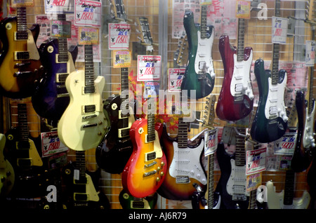 Guitars on display in front of a music shop in Shinjuku Tokyo Stock Photo