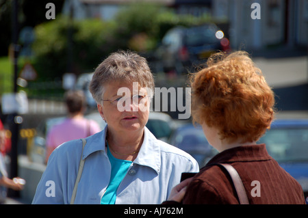 Two women chatting in the street, UK Stock Photo