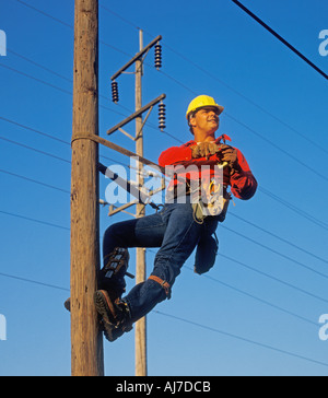telephone worker working on telephone pole Stock Photo