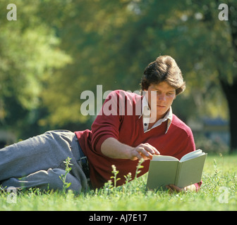 young man relaxing on lawn with a book Stock Photo