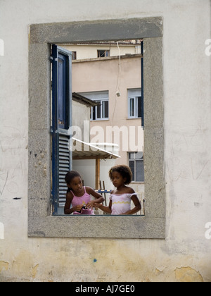 Two girls playing in empty window frame Santa Teresa, Rio de Janeiro, Brazil, South America Stock Photo