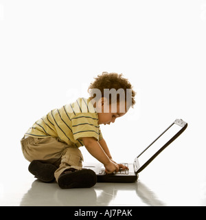 Side view of African American toddler boy using laptop computer Stock Photo