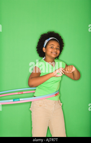 African American girl hula hooping and smiling at viewer Stock Photo