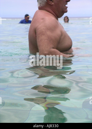 Man with net in backyard pool trying to catch non existent fish