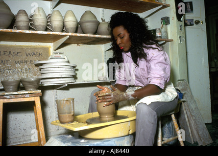 female potter at work throwing a pot on pottery wheel. Stock Photo