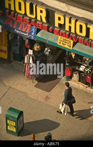 Man walks past sidewalk clothing and luggage display in front of shop in Midtown Manhattan New York NY Stock Photo