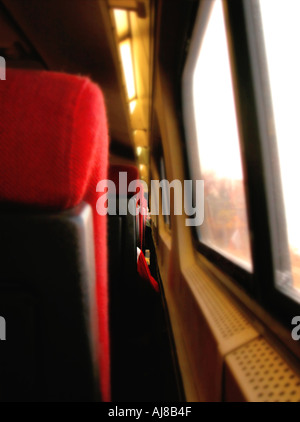 Red Shirt sleeve and red seat next to window on a train Stock Photo
