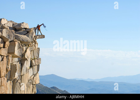 Climber coils rope on the summit. Stock Photo