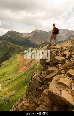 Hiker stands on rocky point.
