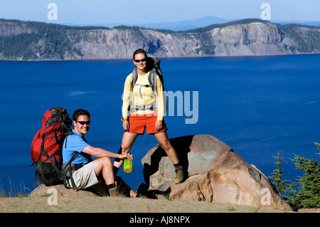 Hikers along cliff trail near lake. Stock Photo