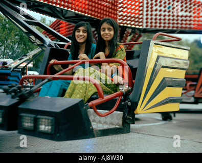 Young Indian girls on a fairground twister during an Indian Mela festival held at Barking Park, London, England Stock Photo